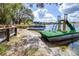 This lake view has a pontoon boat docked on the sand, with a fun slide to make a perfect waterfront home at 1048 Sunset Trail, Babson Park, FL 33827