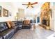 Spacious living room featuring a stone fireplace and a large, comfortable leather sectional at 1048 Sunset Trail, Babson Park, FL 33827