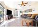 Spacious living room with a ceiling fan, tile flooring, and plenty of natural light at 1048 Sunset Trail, Babson Park, FL 33827