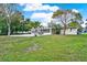 Large, well-maintained backyard with a spacious patio, palm trees and ample green space at 106 Lake Sears Dr, Winter Haven, FL 33880