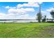 Backyard featuring a well maintained lawn with views of the lake and a wooden dock at 106 Lake Sears Dr, Winter Haven, FL 33880