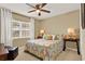 Comfortable bedroom featuring a window, side tables, lamps, and a patterned comforter at 106 Lake Sears Dr, Winter Haven, FL 33880