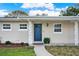 Inviting entrance featuring a blue front door, decorative columns, and manicured landscaping at 106 Lake Sears Dr, Winter Haven, FL 33880