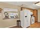 Bright kitchen with white appliances, wooden cabinets, and a pass-through window to the living area with water views at 106 Lake Sears Dr, Winter Haven, FL 33880