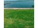 Lush green lawn leading to a sandy beach and the calming waters of a scenic lake at 106 Lake Sears Dr, Winter Haven, FL 33880