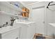 Bright laundry room featuring a utility sink, shelving and modern washing machine and dryer at 106 Lake Sears Dr, Winter Haven, FL 33880