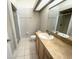 Bathroom featuring tiled floors, glass enclosed shower, and large mirror at 108 Eagle Pond Dr # H, Winter Haven, FL 33884