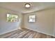 Well-lit bedroom with wood-looking floors and two windows at 114 Bishop St, Auburndale, FL 33823