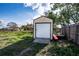 A shed with a roll up door in the backyard of the home at 115 Jefferson St, Lake Wales, FL 33859