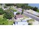 Aerial view of a home, near a road, close to a beautiful lake surrounded by lush greenery and mature trees at 1155 S Lake Shore Way, Lake Alfred, FL 33850