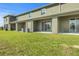 A green lawn that leads up to the back of the townhome with an outdoor patio at 1157 Blue Jay Dr, Davenport, FL 33837