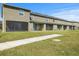 View of the rear exterior of the townhome with screened patio and green lawn at 1157 Blue Jay Dr, Davenport, FL 33837