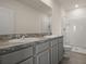 Bathroom with a double sink vanity with granite counters, tile floors, and a shower stall at 1157 Blue Jay Dr, Davenport, FL 33837
