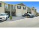 Exterior view of several townhomes, each featuring a garage and a neutral color scheme at 1157 Blue Jay Dr, Davenport, FL 33837