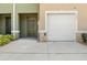Close up view of garage doors and front doors of townhomes with green shrubs in front at 1157 Blue Jay Dr, Davenport, FL 33837