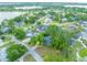 Expansive aerial view of a neighborhood with mature trees, pools, and a scenic lake in the background at 148 Lake Otis Rd, Winter Haven, FL 33884
