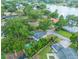 Aerial view of a home with a pool, mature trees, and a lake in the distance, showcasing the neighborhood at 148 Lake Otis Rd, Winter Haven, FL 33884