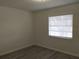 An empty bedroom with wood laminate flooring and a window with horizontal blinds at 148 Lake Otis Rd, Winter Haven, FL 33884
