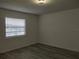 A well-lit bedroom with wood laminate flooring and a window with horizontal blinds at 148 Lake Otis Rd, Winter Haven, FL 33884