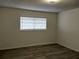 A bedroom with wood laminate flooring and a window with horizontal blinds at 148 Lake Otis Rd, Winter Haven, FL 33884