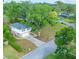 Two-story home with brick accents, a charming tree, and a driveway leading to an attached garage at 148 Lake Otis Rd, Winter Haven, FL 33884