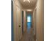 A hallway with wood laminate flooring that leads to a room with window at 148 Lake Otis Rd, Winter Haven, FL 33884