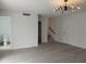 Open-concept living room with modern light fixture, neutral walls, and stairs at 148 Lake Otis Rd, Winter Haven, FL 33884