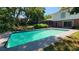 Backyard view of a refreshing in-ground pool with mature trees at 148 Lake Otis Rd, Winter Haven, FL 33884