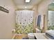 Bright bathroom with floral shower curtain, vanity, and towels at 1510 Shorewood Dr, Auburndale, FL 33823