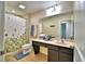 Bright bathroom featuring a shower with floral curtain, large mirror, and vanity at 1510 Shorewood Dr, Auburndale, FL 33823
