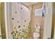 Cozy bathroom featuring a shower with floral curtain, toilet, and window at 1510 Shorewood Dr, Auburndale, FL 33823