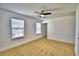 Bright, carpeted bedroom featuring two windows, ceiling fan, and white trim at 1510 Shorewood Dr, Auburndale, FL 33823