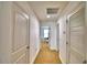 Hallway with neutral carpet and white walls leading to various rooms, providing seamless connectivity at 1510 Shorewood Dr, Auburndale, FL 33823