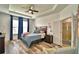 Serene main bedroom featuring tray ceilings, wood floors, and ensuite bathroom access at 1510 Shorewood Dr, Auburndale, FL 33823