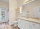 Bright bathroom featuring a white vanity with a sink, a mirror, and a door to the pool at 153 Brookshire Dr, Lake Wales, FL 33898