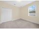 Bedroom with neutral walls, standard closet, carpet, and large window for natural light and exterior view at 153 Brookshire Dr, Lake Wales, FL 33898