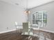 Bright dining room features a modern glass table and chairs beneath an elegant chandelier and large window at 153 Brookshire Dr, Lake Wales, FL 33898