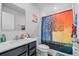 Colorful bathroom featuring a modern vanity, a stylish shower curtain, and ample lighting at 177 Piave St, Haines City, FL 33844