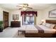 Spacious bedroom featuring a ceiling fan, dark wood furniture and an adjoining sitting area at 1815 Adams Barn Rd, Lake Alfred, FL 33850