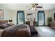 Well-lit bedroom with a ceiling fan, a seating bench, and a tv above a modern dresser at 1815 Adams Barn Rd, Lake Alfred, FL 33850
