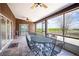 Enclosed patio with tiled flooring and a six-seat table, providing views of the greenery at 1815 Adams Barn Rd, Lake Alfred, FL 33850