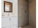 Bathroom featuring a dark shower tile, vanity with a white countertop, and decorative mirror at 1817 Mckeown Ave, Haines City, FL 33844
