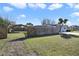 Spacious front yard with a partial fence enclosing the property and mature trees offering ample shade at 1817 Mckeown Ave, Haines City, FL 33844
