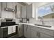 Updated kitchen features stainless steel appliances, gray cabinets, white countertops, and subway tile backsplash at 1817 Mckeown Ave, Haines City, FL 33844