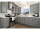 Updated kitchen features stainless steel appliances, gray cabinets, white countertops, and subway tile backsplash at 1817 Mckeown Ave, Haines City, FL 33844