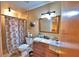 Standard bathroom featuring a vanity with mirror, toilet, and a tiled shower with a floral shower curtain at 20 24Th Sw St, Winter Haven, FL 33880