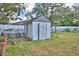 Backyard shed is constructed from wood with a weathered door, and is surrounded by sparse grass at 20 24Th Sw St, Winter Haven, FL 33880