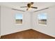 Cozy bedroom boasts hardwood floors, two sunlit windows with blinds, and a neutral color palette at 2048 Fox Run Ln, Lake Wales, FL 33898