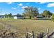 Property with house in the distance and a fenced in yard under a cloudy sky at 2048 Fox Run Ln, Lake Wales, FL 33898