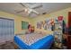 A bedroom with wood-look flooring, a ceiling fan, a window, and a variety of storage and decorative items at 253 Blackwell Villa Cv, Babson Park, FL 33827